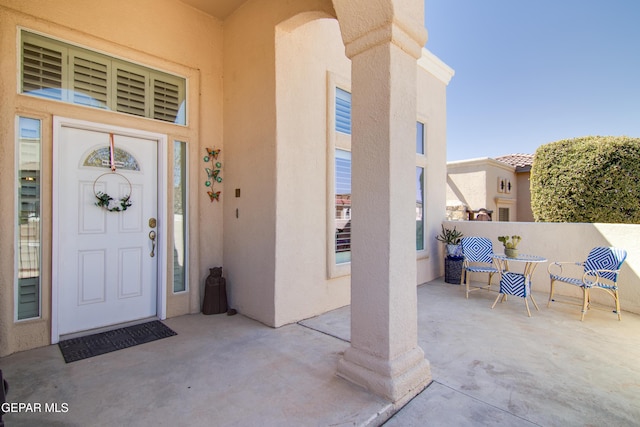 entrance to property with a patio and stucco siding