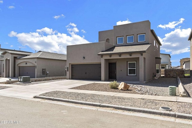 pueblo-style home featuring stucco siding, a garage, and driveway