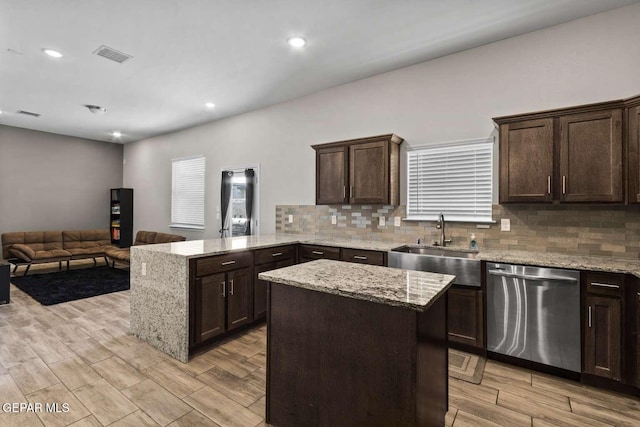 kitchen with visible vents, a peninsula, a sink, dark brown cabinets, and stainless steel dishwasher