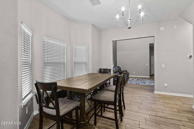 dining area with baseboards, visible vents, wood tiled floor, vaulted ceiling, and a chandelier