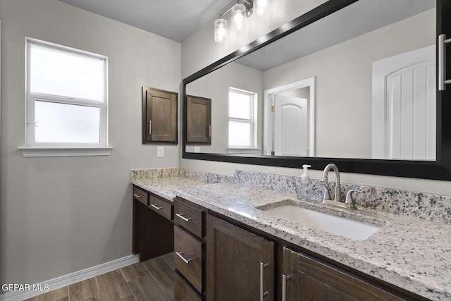 bathroom featuring vanity, baseboards, and wood finished floors