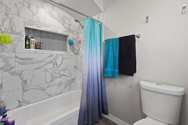 bathroom with shower / tub combo, toilet, and baseboards