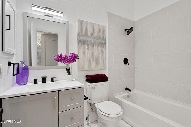 bathroom featuring toilet, shower / washtub combination, vanity, and a textured wall