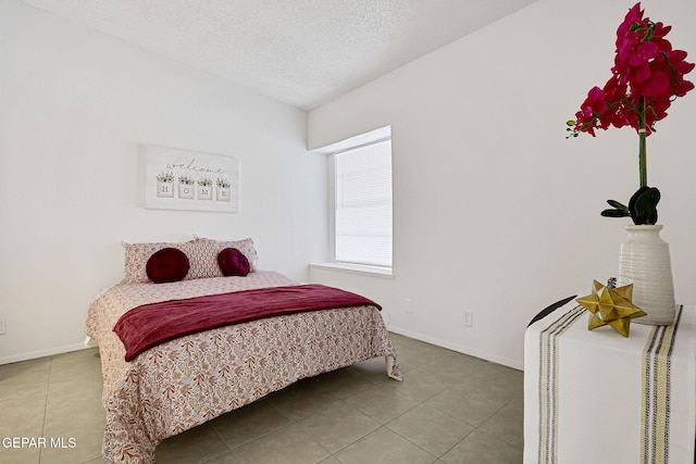 tiled bedroom featuring baseboards and a textured ceiling