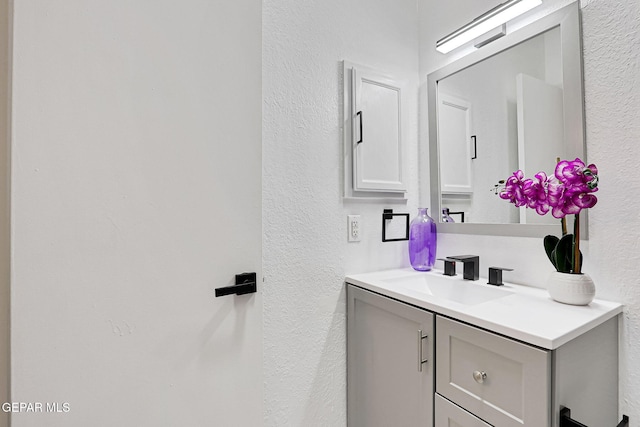 bathroom featuring vanity and a textured wall