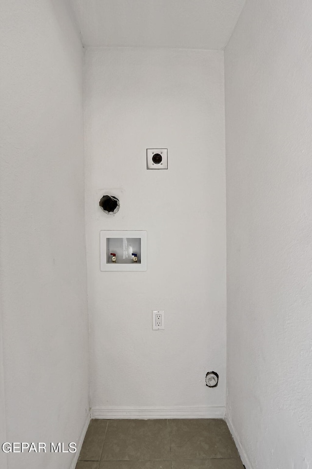 clothes washing area featuring baseboards, laundry area, hookup for a washing machine, electric dryer hookup, and dark tile patterned flooring