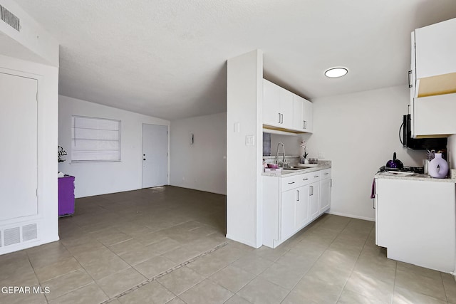 kitchen with a sink, visible vents, white cabinets, and light countertops