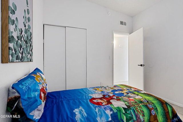 bedroom with a closet, visible vents, and baseboards