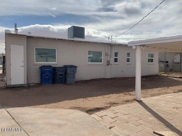 back of property featuring stucco siding and central AC