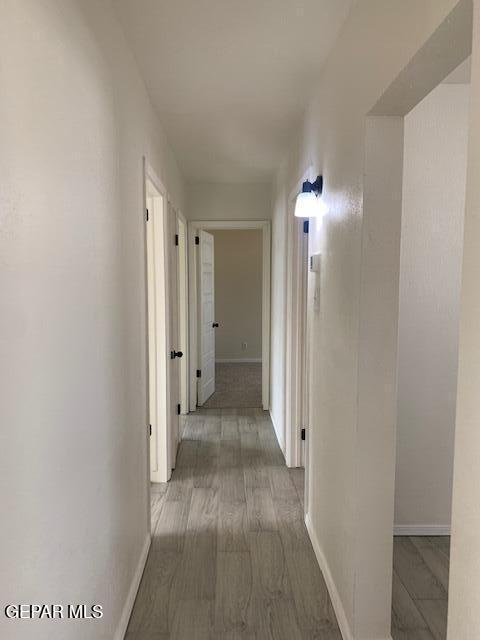 hallway with baseboards and wood finished floors