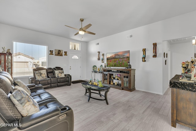 living area with visible vents, baseboards, ceiling fan, and light wood-style flooring