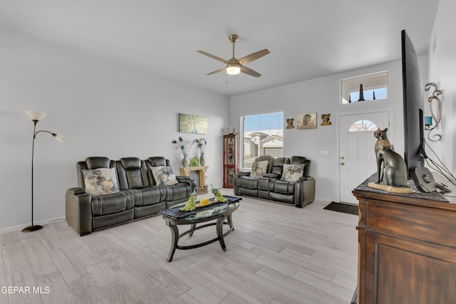 living room with baseboards, light wood-style flooring, and a ceiling fan