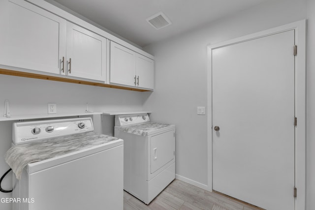 laundry room featuring baseboards, visible vents, cabinet space, separate washer and dryer, and light wood-type flooring