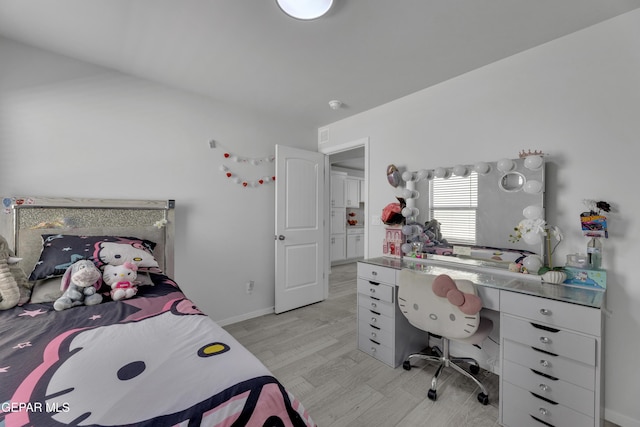 bedroom featuring light wood finished floors and baseboards