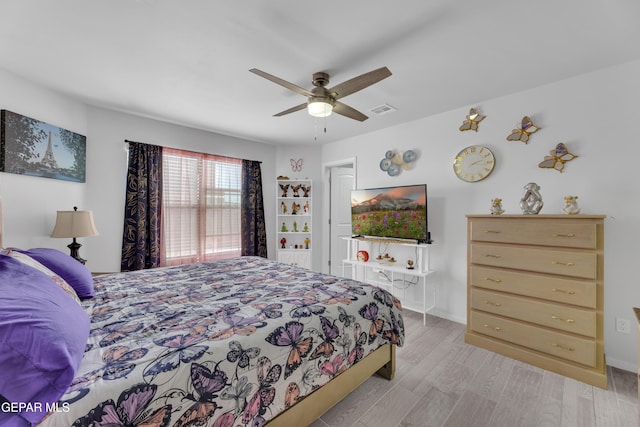 bedroom with light wood-style flooring, a ceiling fan, and visible vents