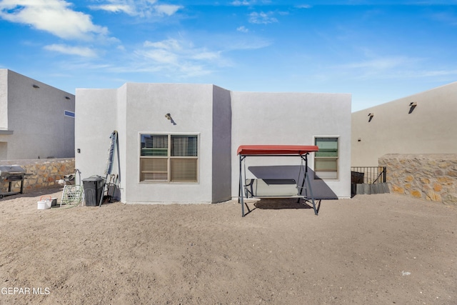 rear view of property featuring stucco siding