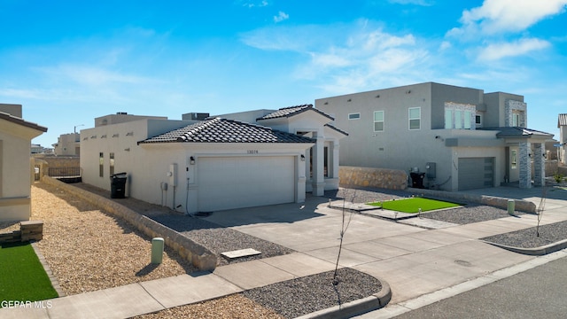 view of front of property with concrete driveway, a tiled roof, a garage, and stucco siding