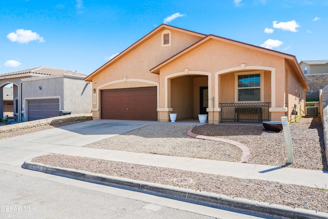 view of front facade with driveway, covered porch, central AC, stucco siding, and a garage