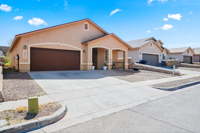 view of front of home with stucco siding, driveway, and a garage