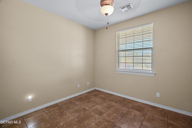 unfurnished room featuring visible vents, a ceiling fan, and baseboards