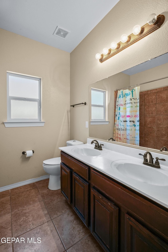 bathroom with tile patterned flooring, visible vents, toilet, and a sink