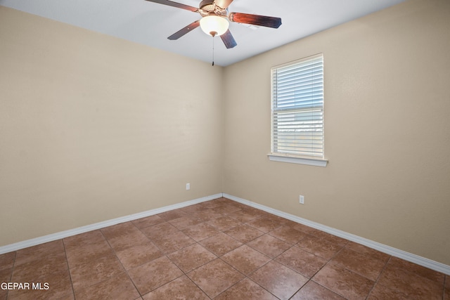 tiled spare room featuring baseboards and ceiling fan