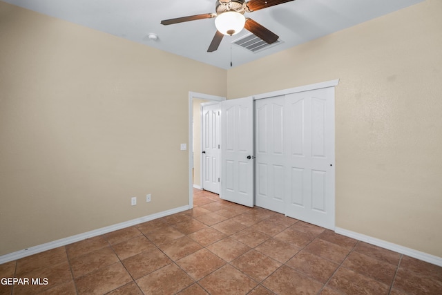 unfurnished bedroom with tile patterned floors, visible vents, baseboards, and a closet