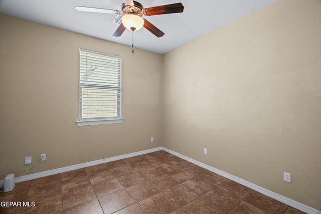 unfurnished room with tile patterned floors, baseboards, and ceiling fan