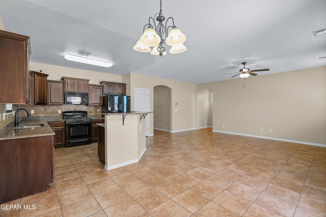 kitchen with visible vents, arched walkways, a sink, black appliances, and ceiling fan with notable chandelier