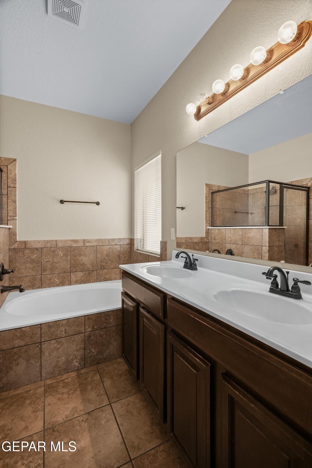 bathroom featuring double vanity, visible vents, a garden tub, and a sink