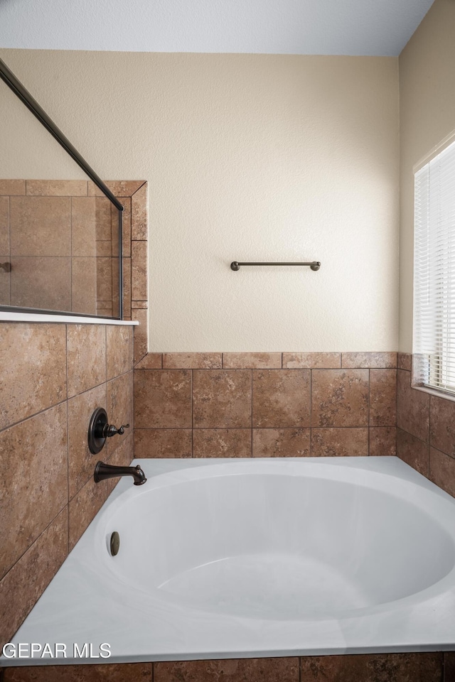 full bathroom featuring a washtub and a shower