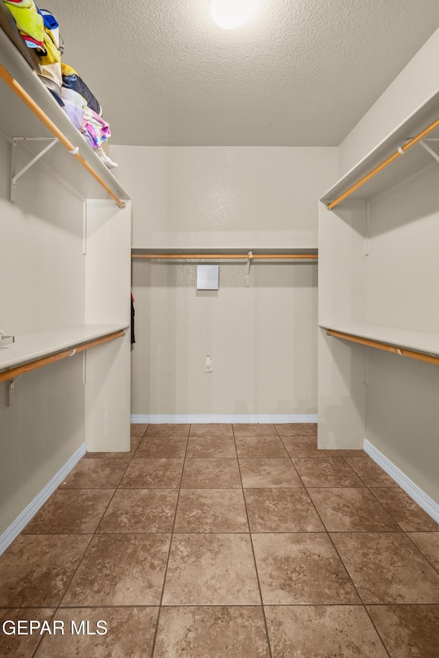 spacious closet featuring tile patterned flooring