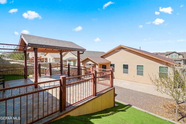 wooden terrace with a patio, a fenced backyard, and a residential view