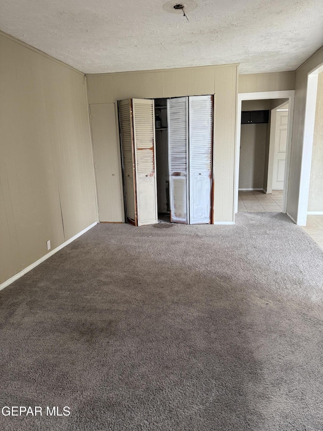 unfurnished bedroom with a closet, a textured ceiling, and carpet