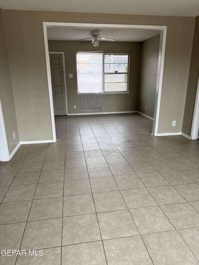 unfurnished room featuring light tile patterned floors, baseboards, and ceiling fan