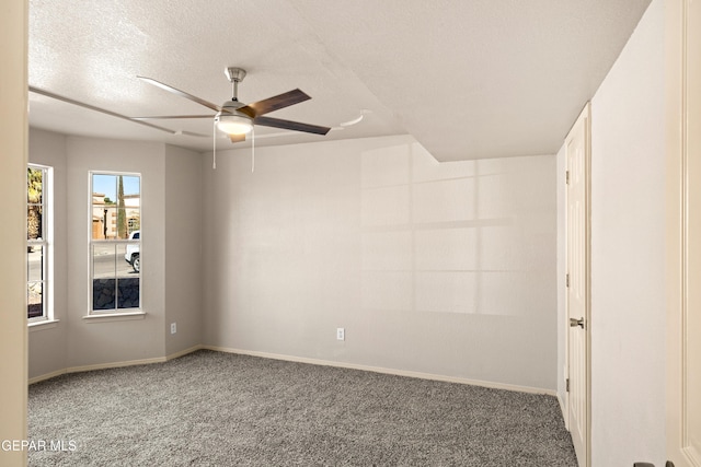 carpeted spare room with baseboards, a textured ceiling, and ceiling fan