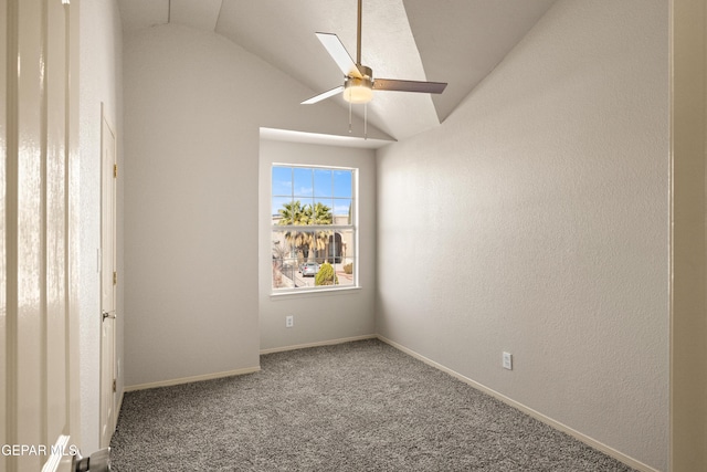 empty room featuring baseboards, carpet, ceiling fan, and vaulted ceiling