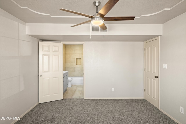 unfurnished bedroom with a textured ceiling, baseboards, visible vents, and light carpet