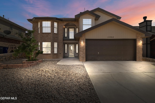 traditional home with brick siding, driveway, and a garage