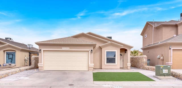 ranch-style home featuring concrete driveway, an attached garage, roof with shingles, and stucco siding