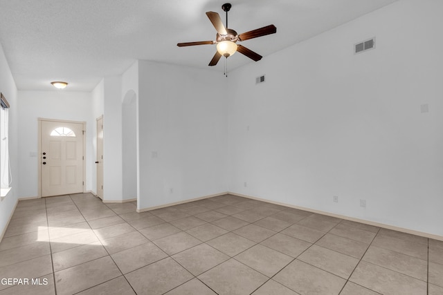 unfurnished room featuring light tile patterned floors, baseboards, visible vents, and ceiling fan