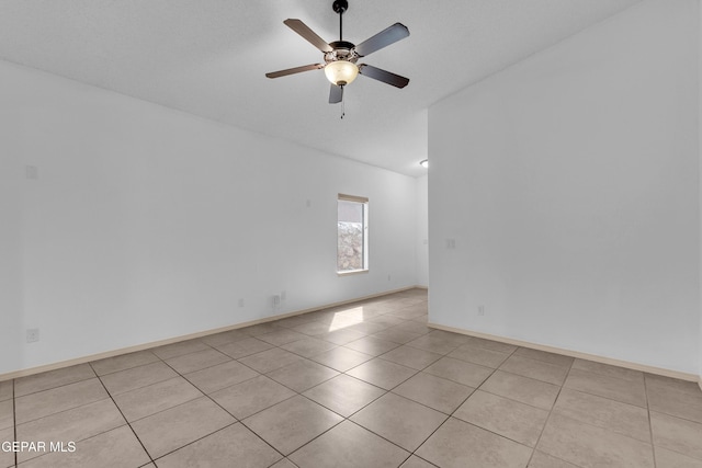 empty room featuring light tile patterned floors, baseboards, and ceiling fan