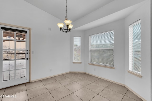 unfurnished dining area with light tile patterned floors, baseboards, a chandelier, and vaulted ceiling