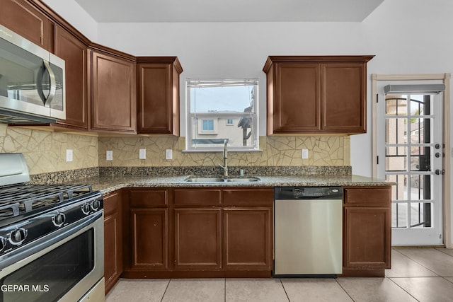 kitchen with a sink, stainless steel appliances, tasteful backsplash, and a wealth of natural light