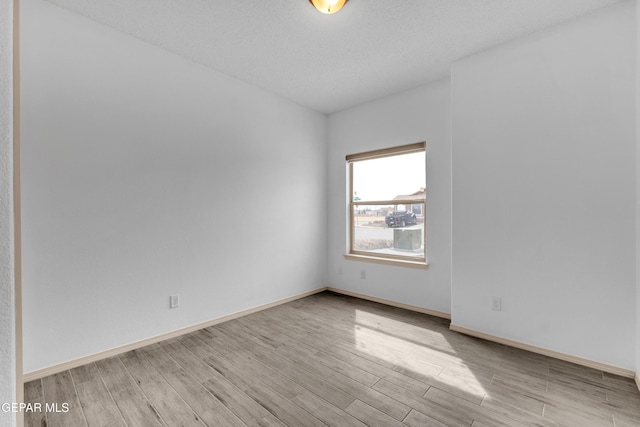 unfurnished room featuring light wood-style flooring and baseboards