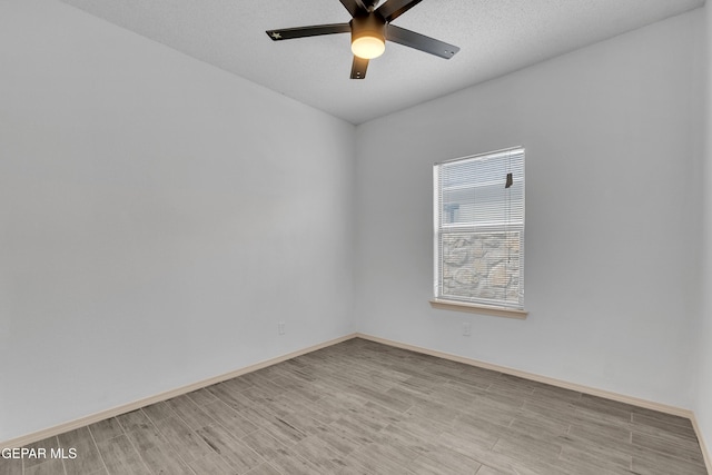 unfurnished room featuring a textured ceiling, a ceiling fan, light wood-type flooring, and baseboards