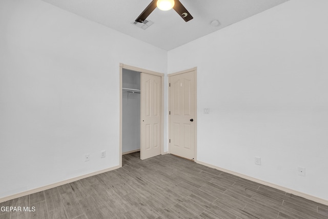 unfurnished bedroom featuring visible vents, baseboards, wood finished floors, a closet, and a ceiling fan