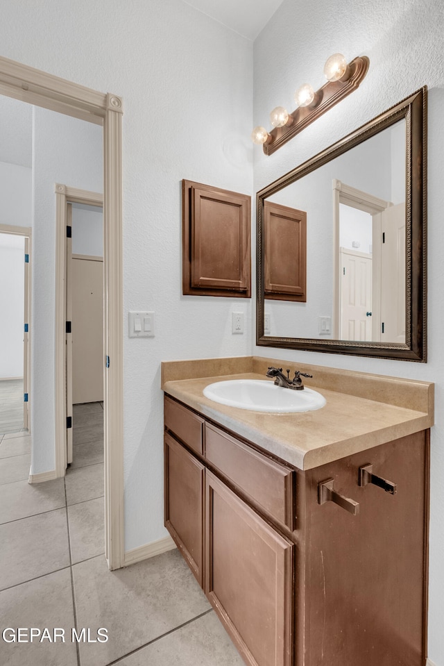 bathroom featuring tile patterned flooring, vanity, and baseboards