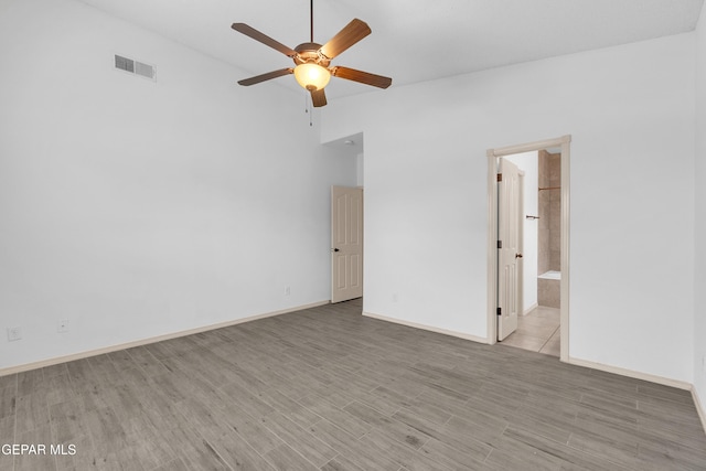 unfurnished room featuring light wood-type flooring, visible vents, baseboards, and ceiling fan