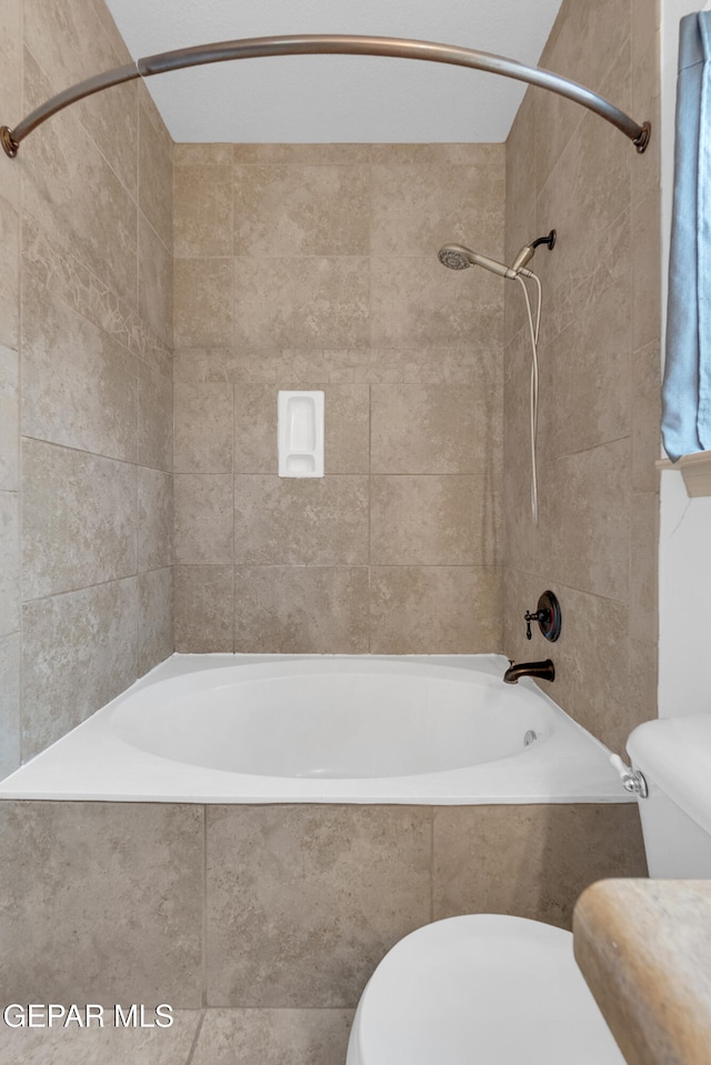 full bath featuring tiled shower / bath combo and toilet